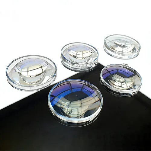 Finished aspheric lenses displayed on a black surface, featuring blue and purple anti-reflective vacuum coatings to improve light transmission for camera and sensor systems.