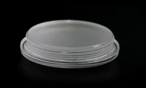 A circular semi-transparent plastic outdoor lamp cover on a black background, featuring a flat-topped stepped disc structure with a clear protruding flange rim around the base for mounting.