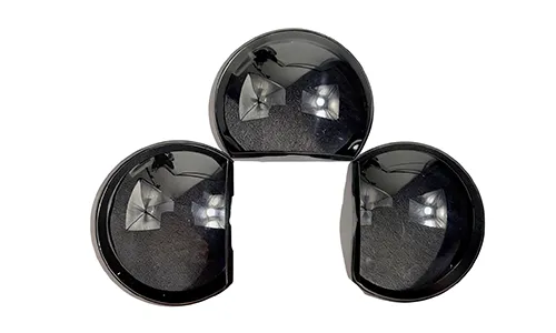 Three black precision plastic optical lens components arranged in a triangular layout on a solid white background, featuring smooth glossy surfaces with subtle light reflections.